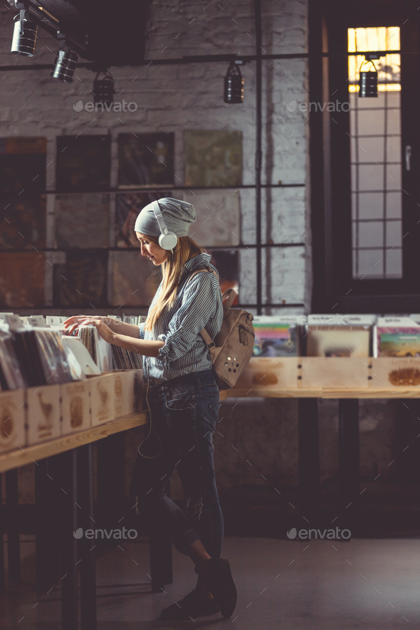 Young girl listening to music in a vinyl record store Stock Photo by AboutImages