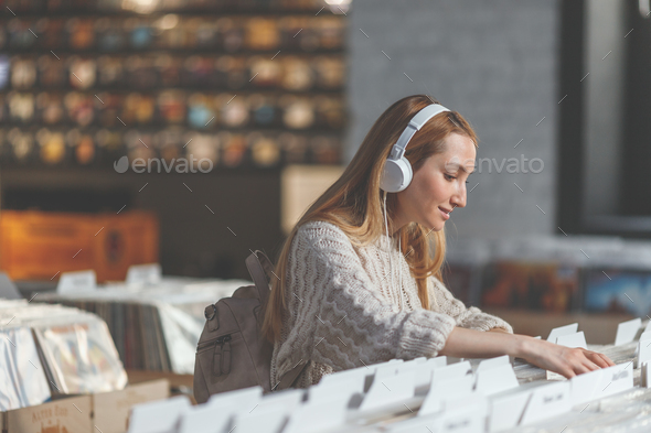 Young girl browsing records in a store Stock Photo by AboutImages | PhotoDune