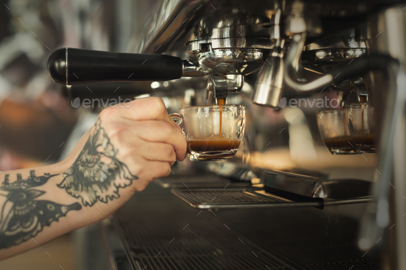 Closeup of female hand brewing espresso in professional coffee machine - Stock Photo - Images