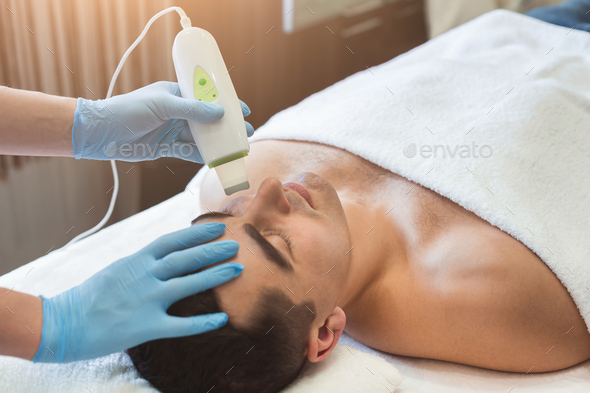 Man getting facial treatment at beauty salon - Stock Photo - Images