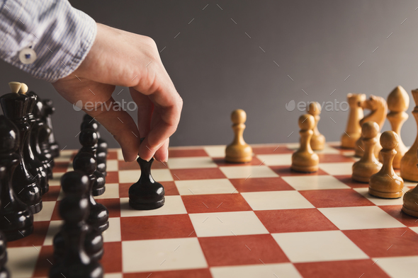 Hand of player chess board game putting black pawn - Stock Photo - Images