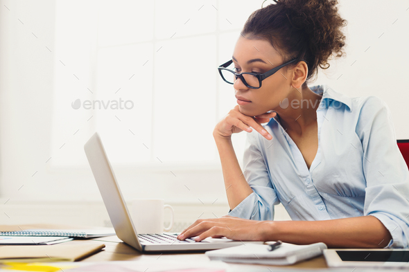 Pensive business woman working on laptop at office - Stock Photo - Images