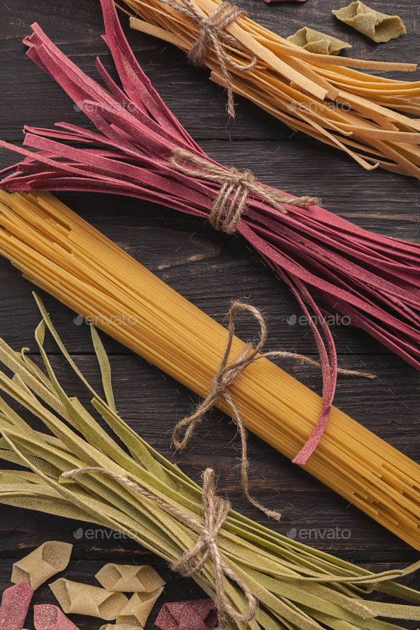 Pile of purple and green fettuccine pasta on wood, closeup - Stock Photo - Images