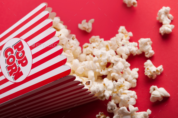 Bucket of popcorn on red background - Stock Photo - Images