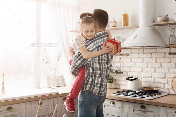 Cute child girl giving gift to dad at home - Stock Photo - Images