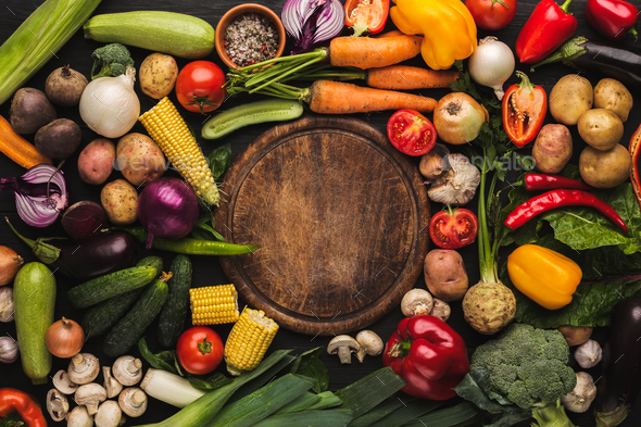 Fresh organic vegetables and wooden board background - Stock Photo - Images