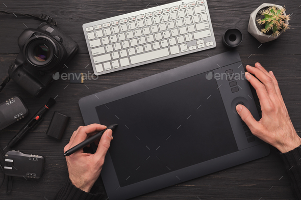 Designer hand with graphic tablet and keyboard Stock Photo by Prostock-studio