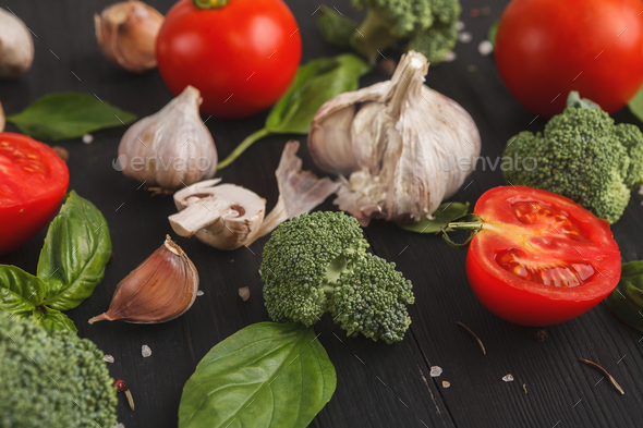 Fresh tomatoes and garlic closeup on dark rustic wood - Stock Photo - Images