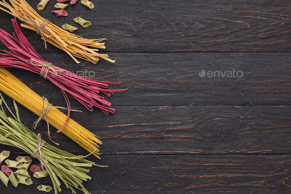 Pile of purple and green fettuccine pasta on wooden background - Stock Photo - Images