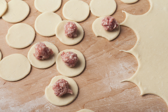 Preparing dumplings with meat, forming small ravioli - Stock Photo - Images