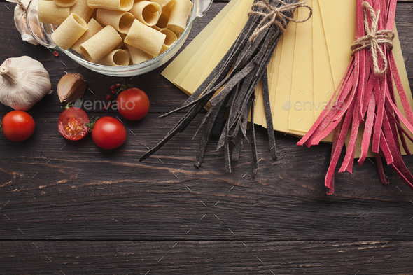 Red italian pasta and cooking ingredients on wooden table - Stock Photo - Images
