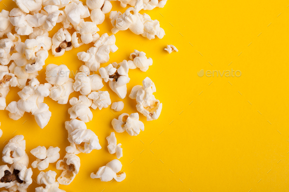 Slaty popcorn scattered on yellow background, top view - Stock Photo - Images
