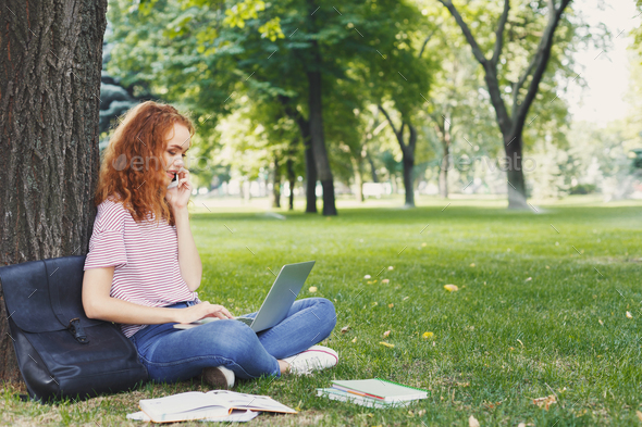 Attractive student with laptop and notebook outdoors - Stock Photo - Images