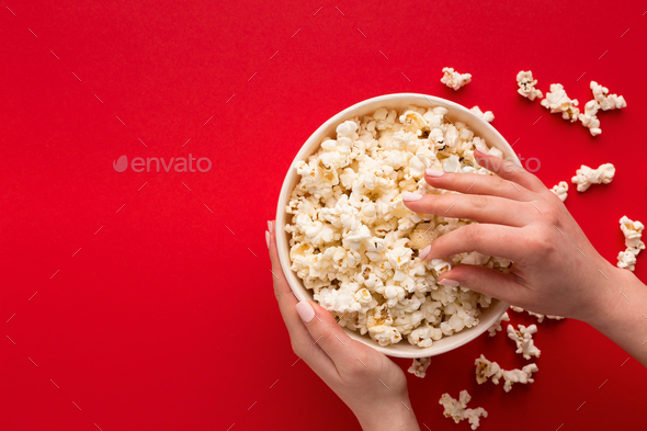 Bucket of popcorn on red background, top view - Stock Photo - Images