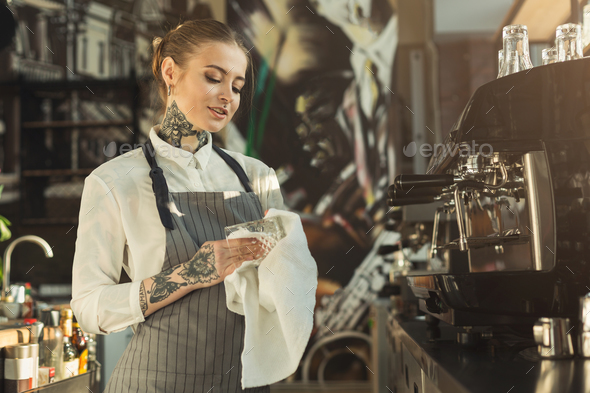 Portrait of tattooed barista at coffee shop counter - Stock Photo - Images