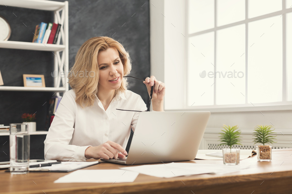 Serious businesswoman working on laptop at office - Stock Photo - Images