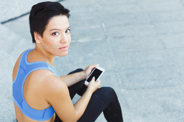 Female runner with smartphone on stairs - Stock Photo - Images