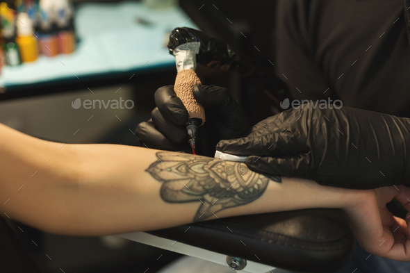 Professional tattoo artist making tattoo on hand - Stock Photo - Images