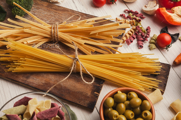 Pasta and cooking ingredients on white wood - Stock Photo - Images