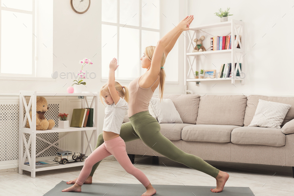 Mother and little daughter doing yoga together - Stock Photo - Images