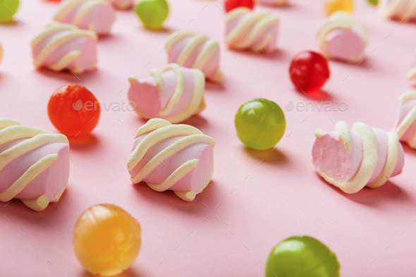 Closeup of marshmallows and colourful sweets on pink background - Stock Photo - Images