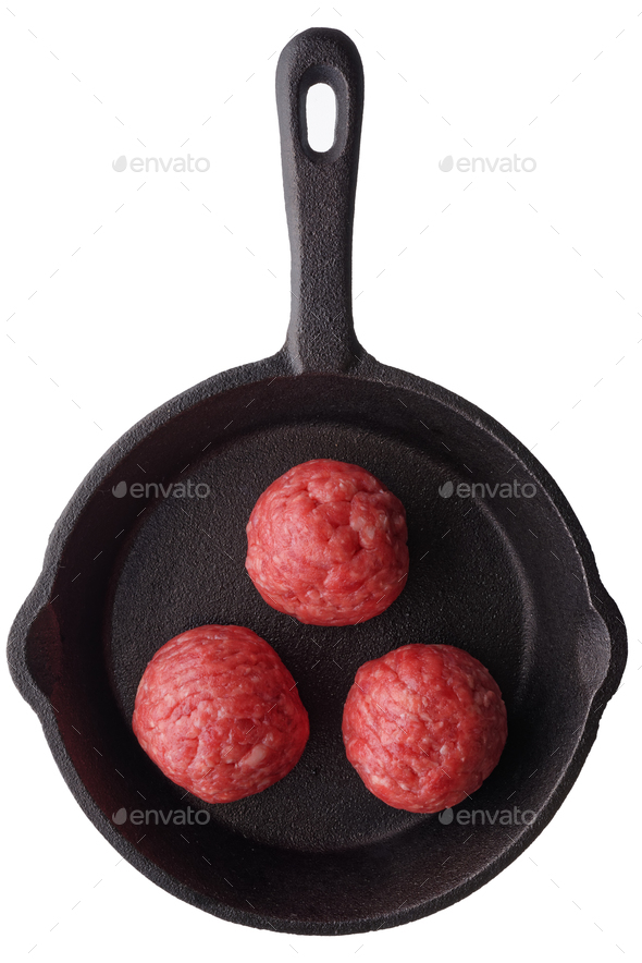 Three uncooked meatballs on a frying pan - Stock Photo - Images