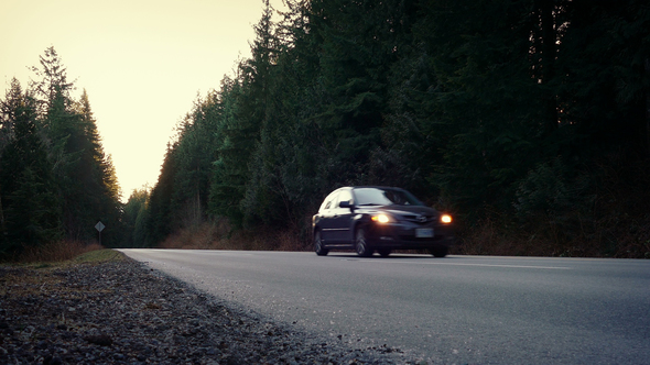 Car Passes On Rural Highway At Dusk alt