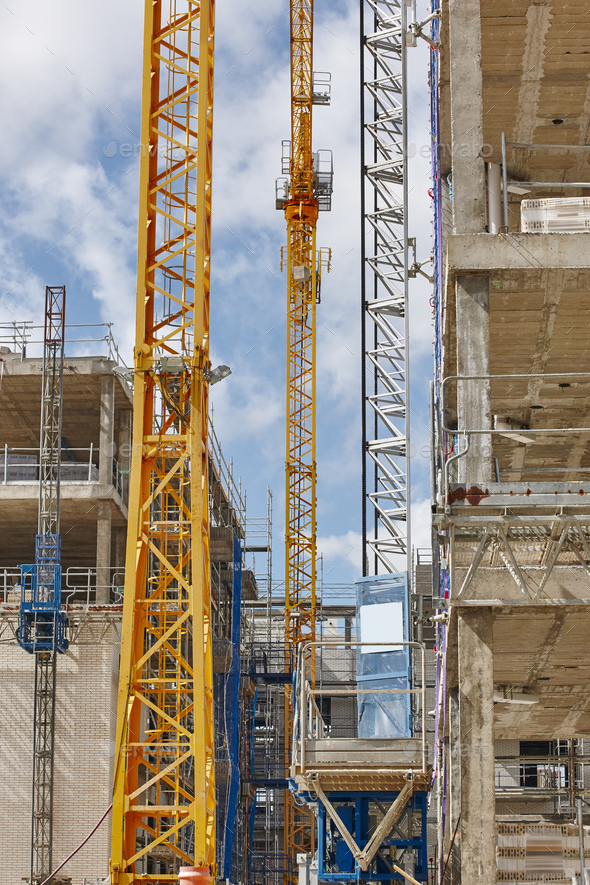 Building under construction. Crane machinery structure. Industry. Vertical Stock Photo by ABBPhoto