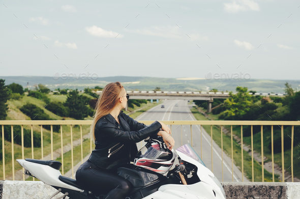 Young woman thinking of new destinations while sitting on bike - Stock Photo - Images
