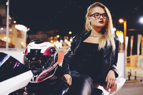 Portrait woman biker enjoying night city life and lights sitting - Stock Photo - Images
