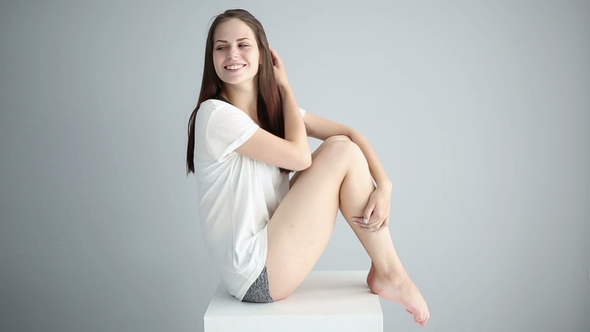 Portrait of a Beautiful Girl in the Studio on a Gray Background