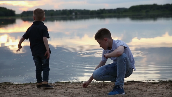 2 Boys Throw Stones in the Pond