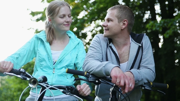 Portrait of a Young Couple with Bicycles in the Park