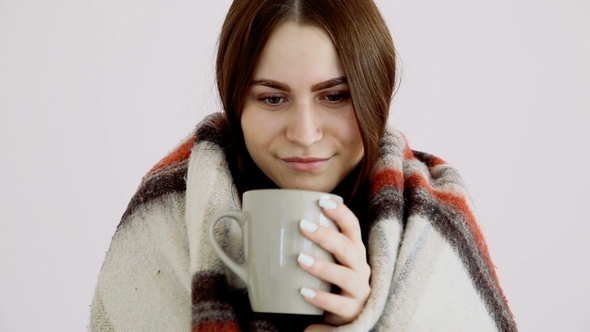 Beautiful Happy Girl of European Appearance in a Woolen Blanket Is Drinking Hot Tea