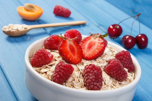 Oat flakes or oatmeal with strawberries and raspberries, healthy lifestyle and nutrition - Stock Photo - Images