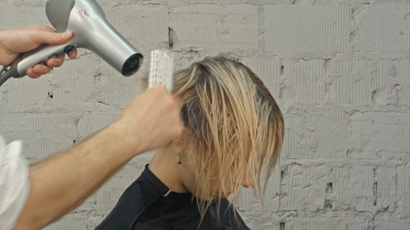 Hairdresser Blowing with Hairdryer Woman's Hair at the Beauty Salon alt