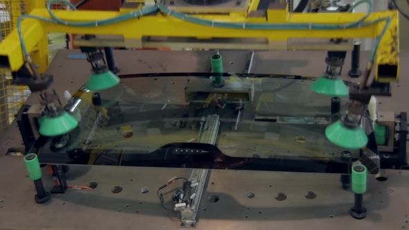 Robot Is Gripping a Back Car Windows and Lifting Up in a Car Factory