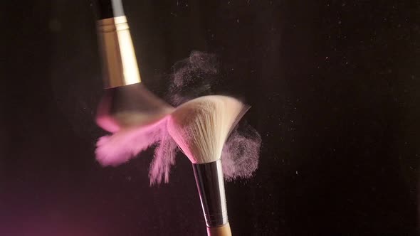 Makeup Brushes Touch Each Other on Dark Background and Small Particles of Cosmetics Slow Motion alt