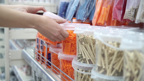 A Woman Chooses Corrugated Plastic Plugs in a Store of Construction Goods alt