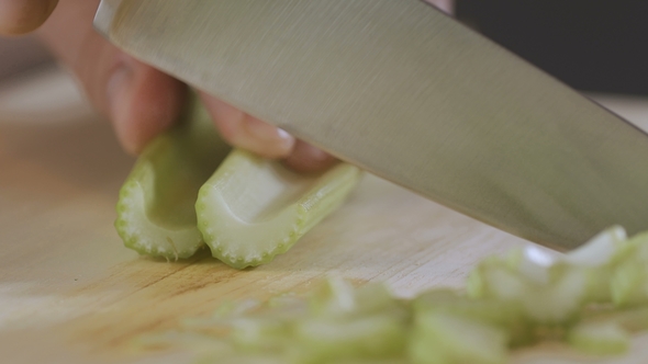 Man Is Cutting a Celery in the Kitchen alt