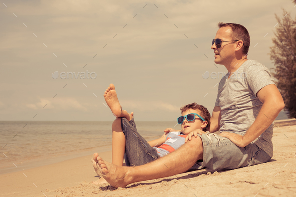 Father and son playing on the beach at the day time. - Stock Photo - Images