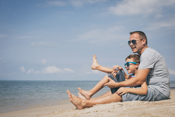 Father and son playing on the beach at the day time. - Stock Photo - Images