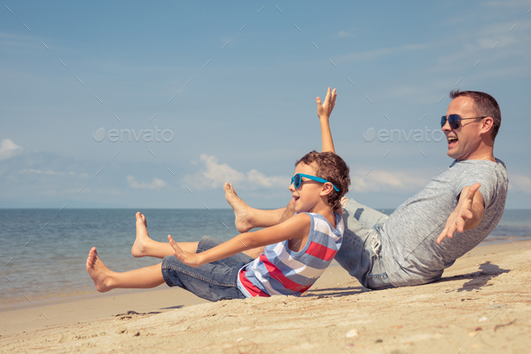 Father and son playing on the beach at the day time. - Stock Photo - Images