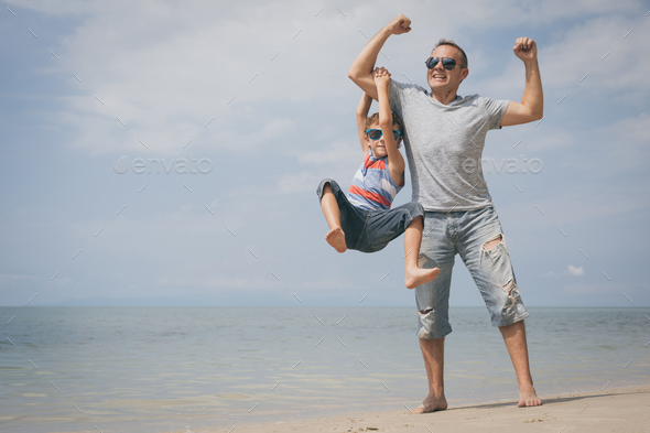 Father and son playing on the beach at the day time. - Stock Photo - Images