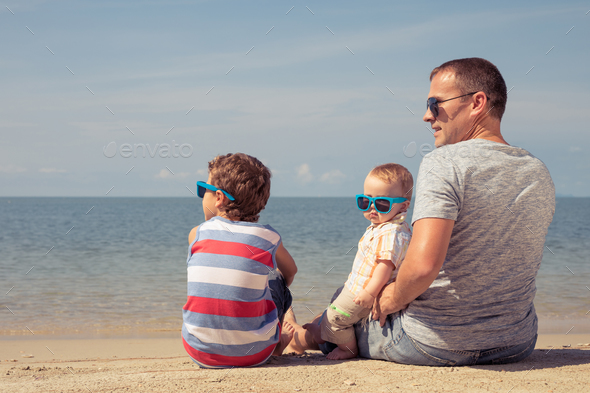 Father and children playing on the beach at the day time. - Stock Photo - Images