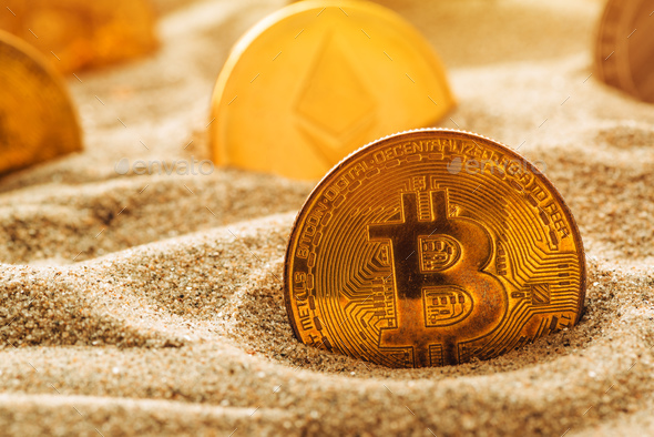 Golden bitcoin in sand - Stock Photo - Images