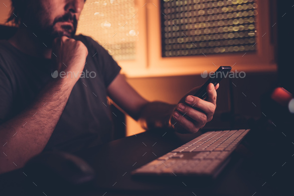 Bored man wasting time using mobile phone Stock Photo by stevanovicigor