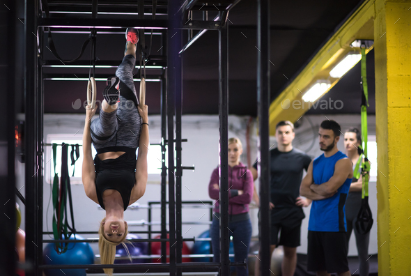 woman working out with personal trainer on gymnastic rings Stock Photo by dotshock