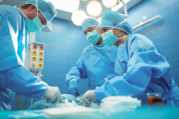 Team of surgeons performing operation in operation theater - Stock Photo - Images