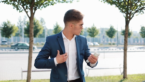 Young Businessman Taking Money Bribe and Purring It To His Jacket Pocket. People, Business